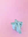 Light Blue gift box on pink background, vertical. Royalty Free Stock Photo