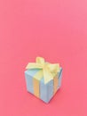 Light blue gift box on rosy pink background. vertical.