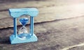 Light blue hourglass on wooden background,vintage color tone Royalty Free Stock Photo