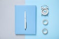 Light blue notebook, alarm clock and tapes on color background, flat lay Royalty Free Stock Photo