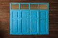 Light blue painted vintage retro wooden windows and panes, home interior architectural design against plain tropical dark brown