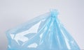 A light blue plastic bag is tied at the top with a white string, sitting on a white surface Royalty Free Stock Photo