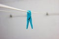 Light blue plastic laundry clip on a hanging wire indoor isolated shallow depth of field Royalty Free Stock Photo