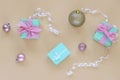 Light blue present boxes with bow on beige background with balls and boubles. Christmas concept. Top view, flat lay