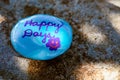 Light blue rock with the words & x22;Happy Days& x27; painted in purple