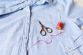 Light blue shirt for women, wooden spool with cotton thread and embroidery scissors