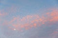 light blue sky and delicate light pink fleecy clouds and a full moon Royalty Free Stock Photo