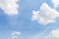 Light blue sky with fluffy white clouds. Airplane trails on blue sky. Contrails in the sky. Sky with traces Royalty Free Stock Photo