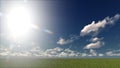 A light blue sky with white clouds on a field