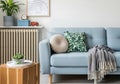 Light blue sofa with green leaf pillows and grey throw Royalty Free Stock Photo