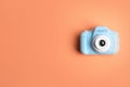 Light blue toy camera on orange background, top view. Future photographer Royalty Free Stock Photo