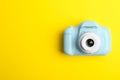 Light blue toy camera on yellow background, top view. Future photographer Royalty Free Stock Photo