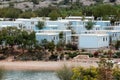 Light blue and white newly built bungalows with front porches surrounded with small trees and rocks near local beach at tourist Royalty Free Stock Photo