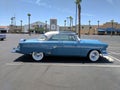 Light blue and white 1950s Ford Crestline in parking lot - passenger side view