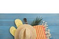 Light blue wooden surface with beach towel, straw hat, flip flops and sunglasses on white background, top view Royalty Free Stock Photo