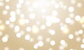 Light bokeh gold background. Festive defocused lights. Holiday glowing white lights with sparkles. Royalty Free Stock Photo