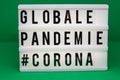 A light box with the inscription: GLOBALE PANDEMIE #CORONA with white background Royalty Free Stock Photo