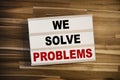 Light box or lightbox with message We Solve Problems on a wooden table background Royalty Free Stock Photo