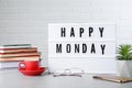 Light box with message Happy Monday, office stationery and cup of coffee on desk Royalty Free Stock Photo