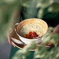 Light breakfast in female hands. Woman holding a saucepan of freshly made rice porridge with berries. Soft focus. Square Royalty Free Stock Photo