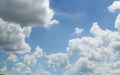 Light bright blue sky with fluffy white towering clouds - Replacement or background Royalty Free Stock Photo