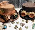 couple steampunk hats, with googles, gears, magnifiers, feather