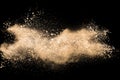 Light brown dust explosion cloud.Brown particles splatter on black background Royalty Free Stock Photo