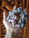 Light brown pattern scrunchie with balinese carved wood as background