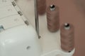 Light brown sewing thread in a row