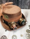 light brown steampunk hat, goggle, spectacle, magnifying glass, feather, ribbon