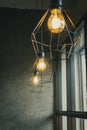 light bulb in black steel cage hang on ceiling in coffee shop, Fashion and lamp in modern style Royalty Free Stock Photo