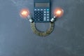 Light bulb coins,calculator and notebook on gray stone backgroun Royalty Free Stock Photo