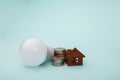 Light bulb with coins stack and house model. Power energy concept