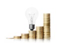 Light bulb on gold coins and graph them Royalty Free Stock Photo