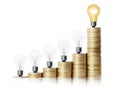 Light bulb on gold coins and graph them Royalty Free Stock Photo