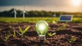 light bulb in the grass concept idea clean energy in nature, lightbulb with solar panel and wind turbine on soil Royalty Free Stock Photo