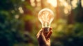 Light bulb hand on nature blur background. generative AI Royalty Free Stock Photo