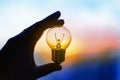 Light bulb in hand at sunset Royalty Free Stock Photo