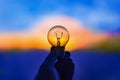 Light bulb in hand at sunset Royalty Free Stock Photo