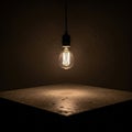 Light bulb hangs above a textured square surface casting a warm Royalty Free Stock Photo