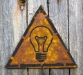 Light Bulb Icon on Rusty Warning Sign.