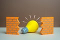 A light bulb idea breaks through the wall. New idea. Super solution. Innovation overcoming limits Royalty Free Stock Photo