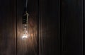 The light bulb illuminates on wooden background Royalty Free Stock Photo