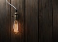 The light bulb illuminates on wooden background Royalty Free Stock Photo