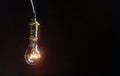 The light bulb illuminates on wooden background Royalty Free Stock Photo