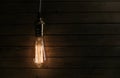 The light bulb illuminates on wooden background Royalty Free Stock Photo