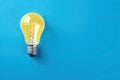 light bulb lit on blue background. winning idea concept. Royalty Free Stock Photo