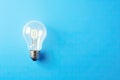 light bulb lit on blue background. winning idea concept. Royalty Free Stock Photo