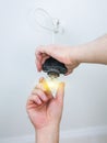 Light bulb in man`s hand. Maintenance repair works renovation in the flat. Restoration indoors. Wires in the ceiling Royalty Free Stock Photo