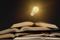 Light bulb and opened vintage book style vintage dark background Royalty Free Stock Photo